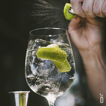 persona aportandole aroma a un Gin&tonic haciendo un twist